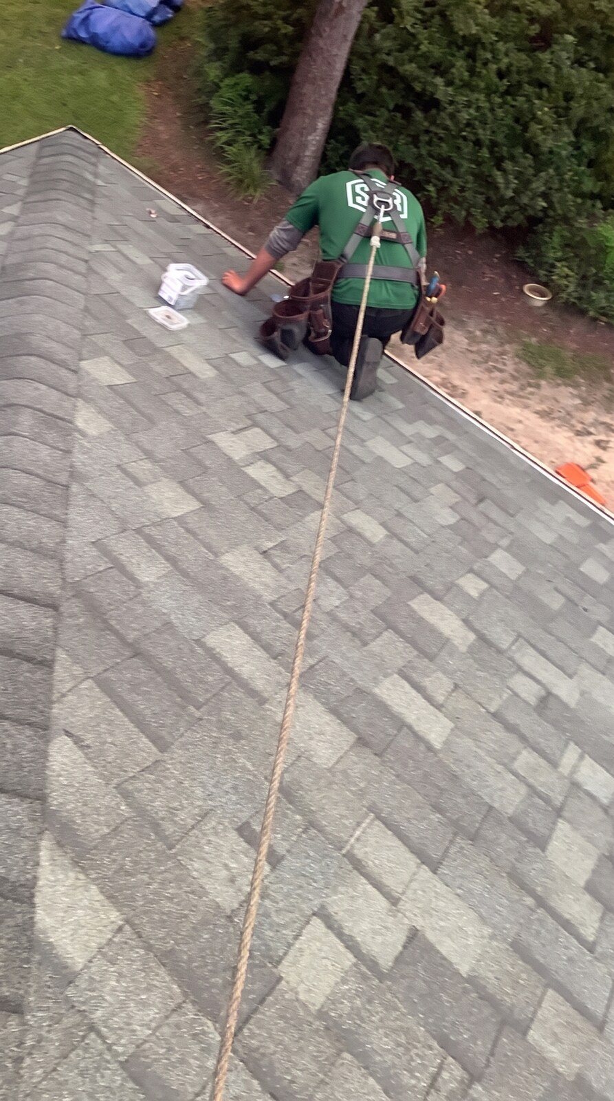 Crew member at the hip on the finished Oakridge roof on a shingle roof in Hernando