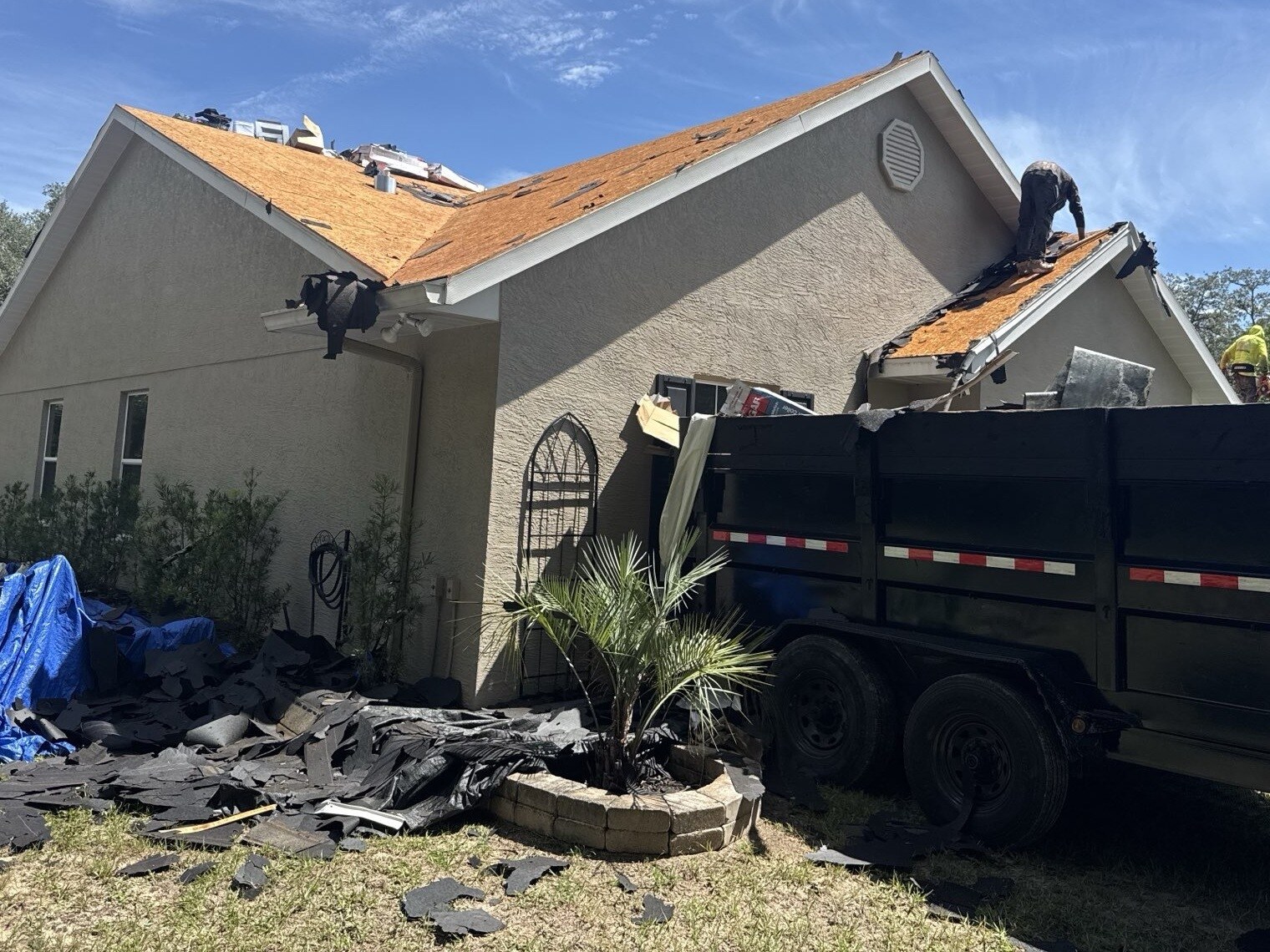 Old shingles going into the dumpster during a Hernando FL roof tear off