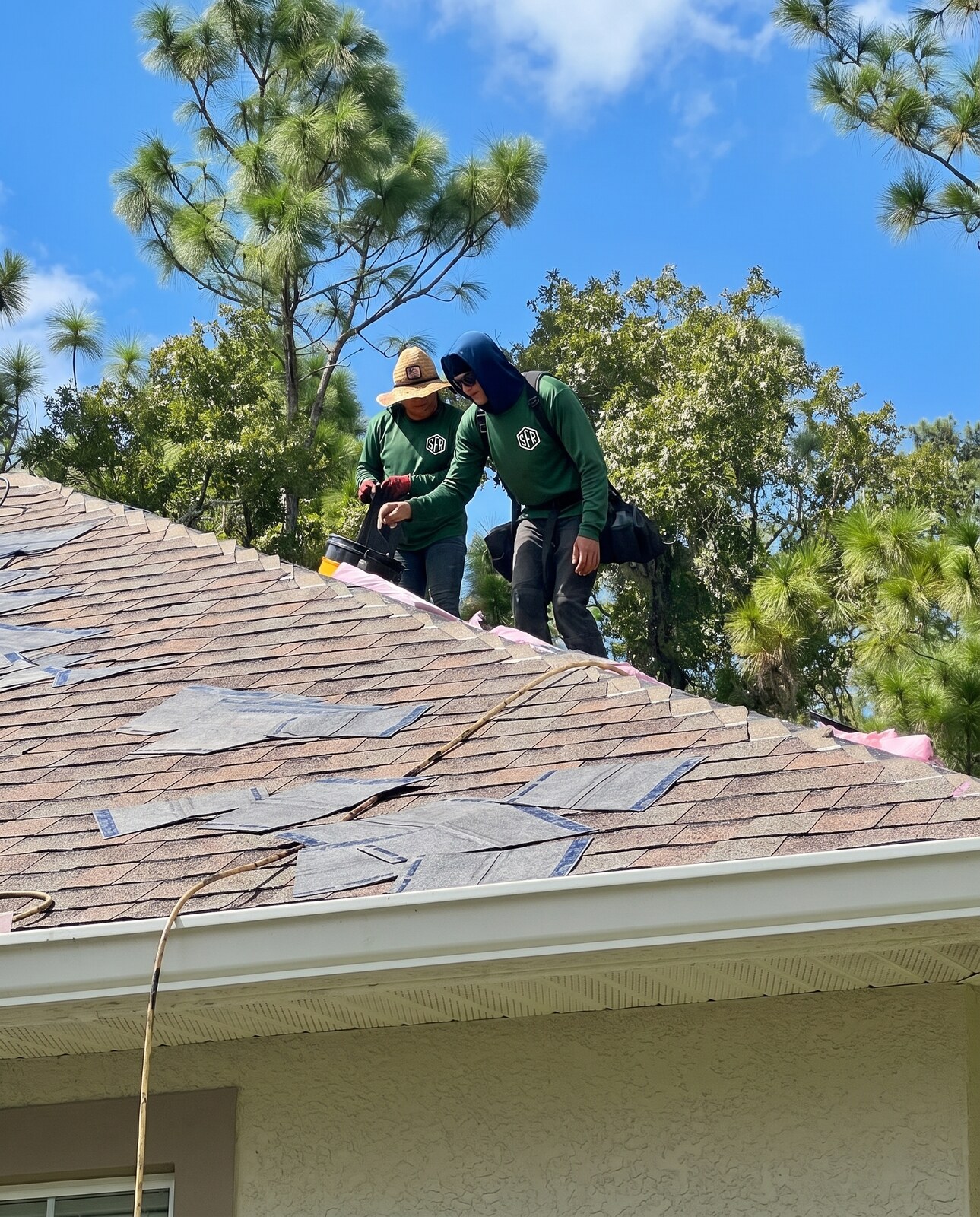 Scotti Family Roofing crew nailing off shingles at the ridge on a Homosassa FL roof replacement
