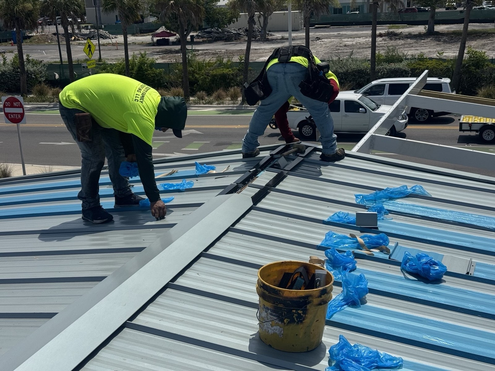 Scotti Family Roofing crew installing metal roof panels on a Holmes Beach FL commercial building