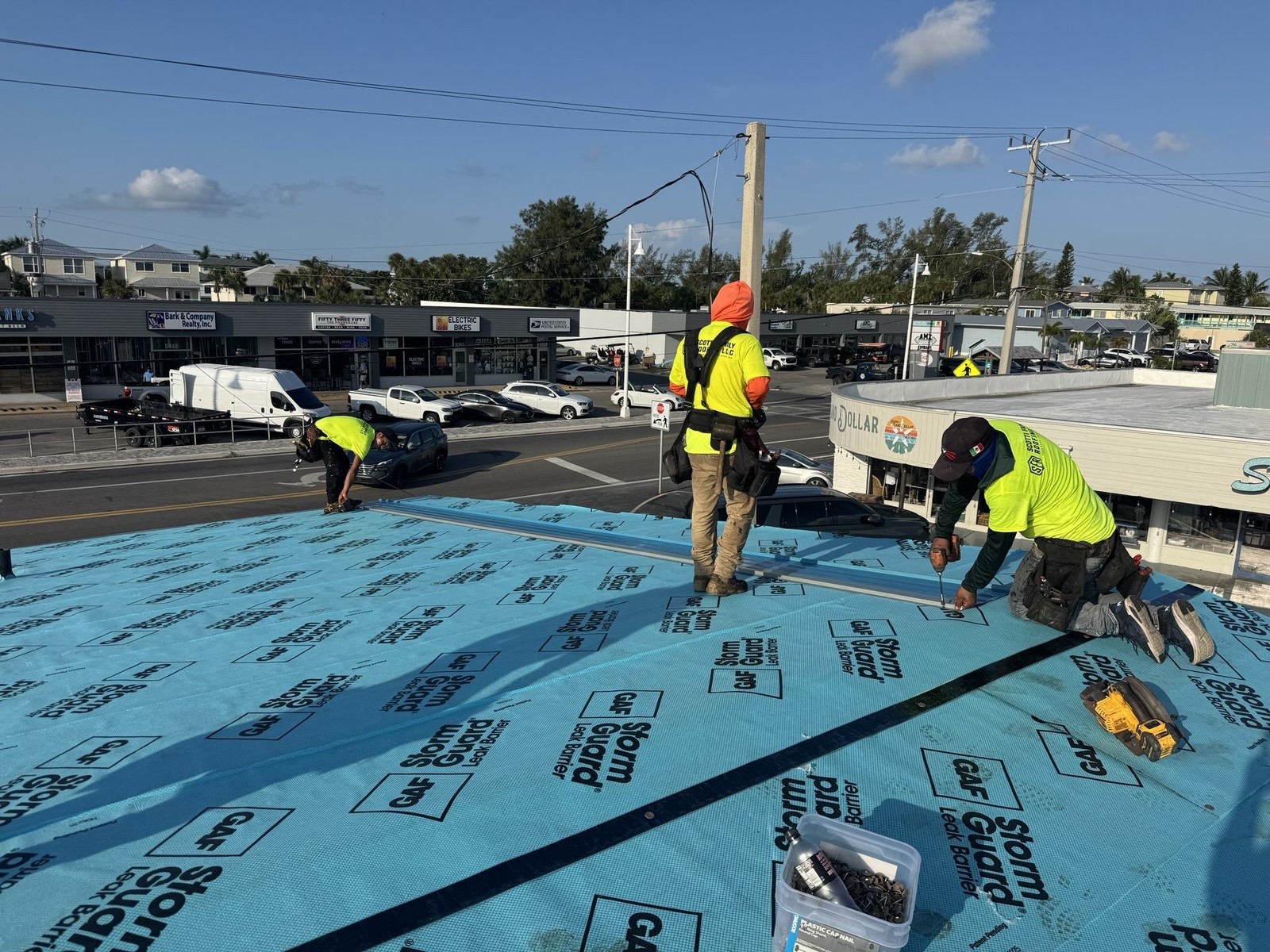 Scotti Family Roofing crew installing underlayment on a low-slope Holmes Beach FL commercial roof