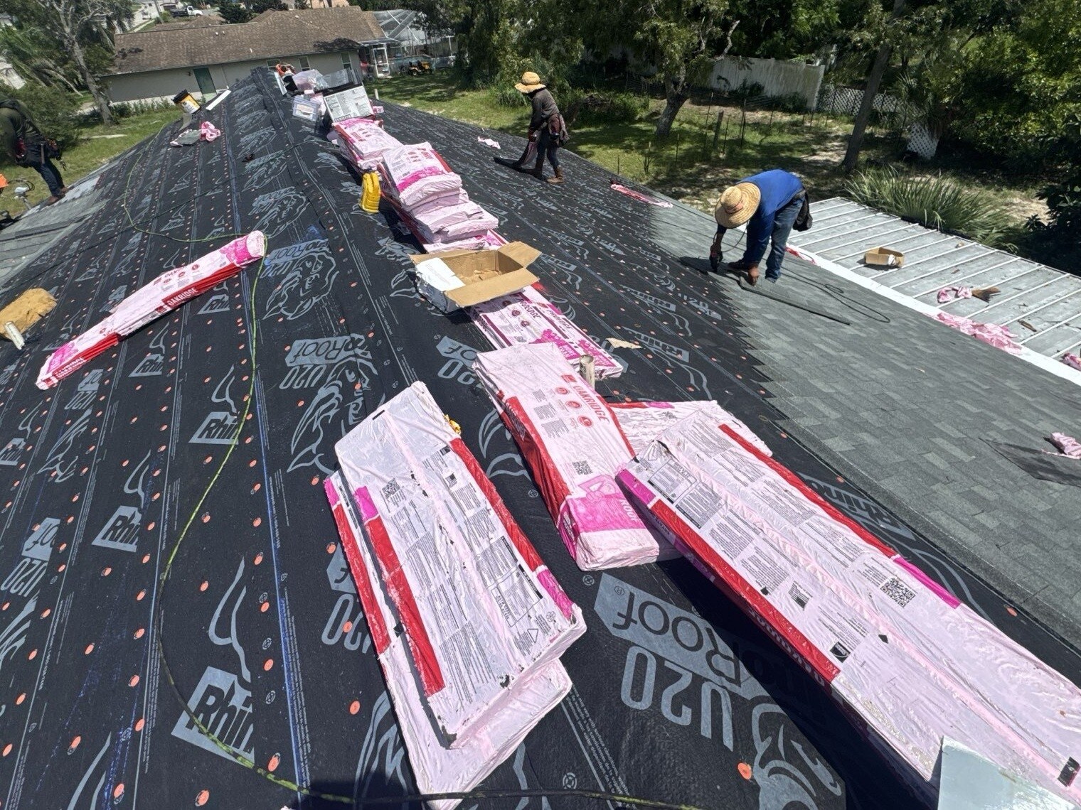 Scotti Family Roofing crew installing synthetic underlayment across a Spring Hill FL roof deck