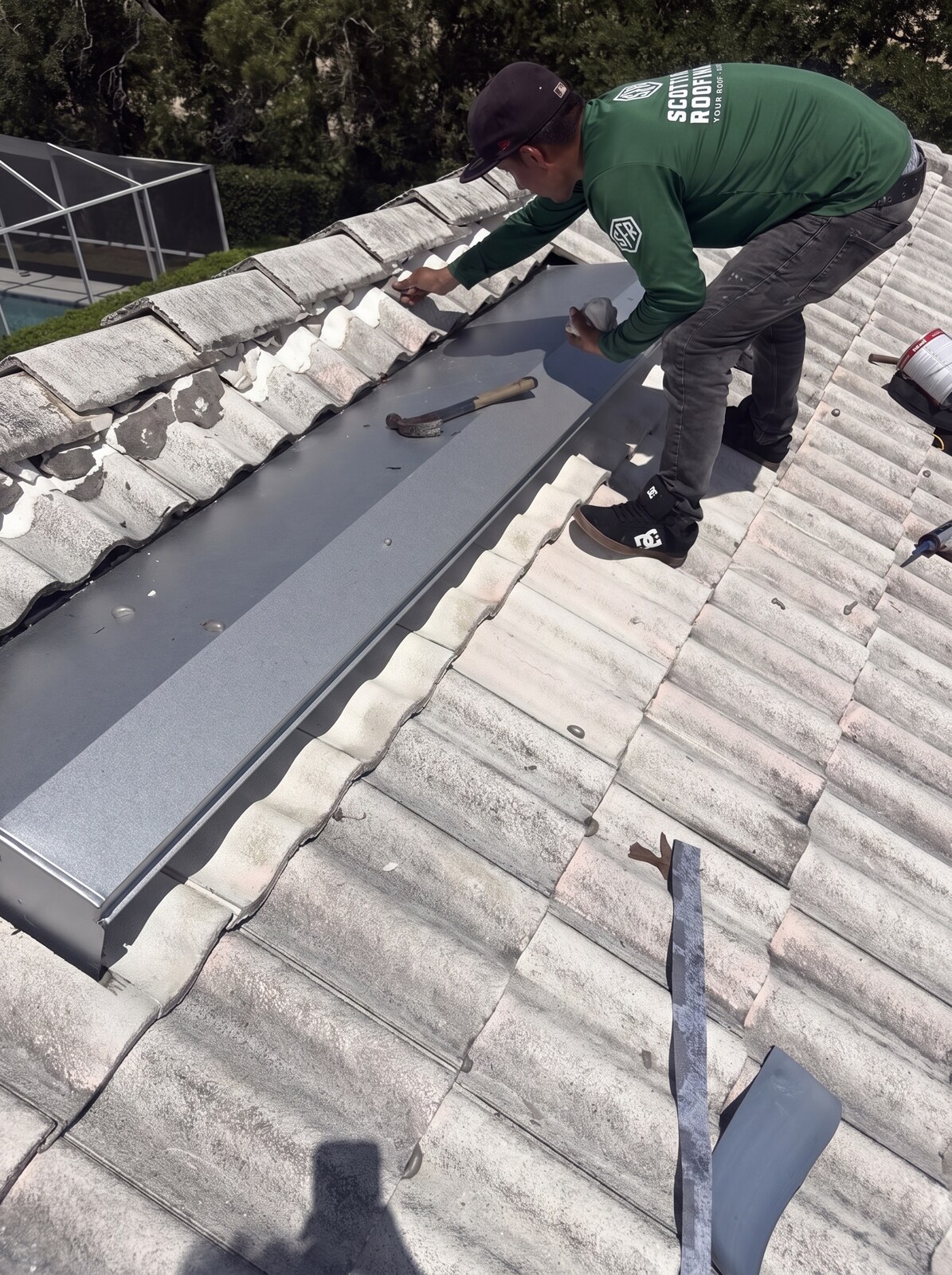 Roofer setting metal at the ridge during a concrete tile roof repair in Weeki Wachee FL