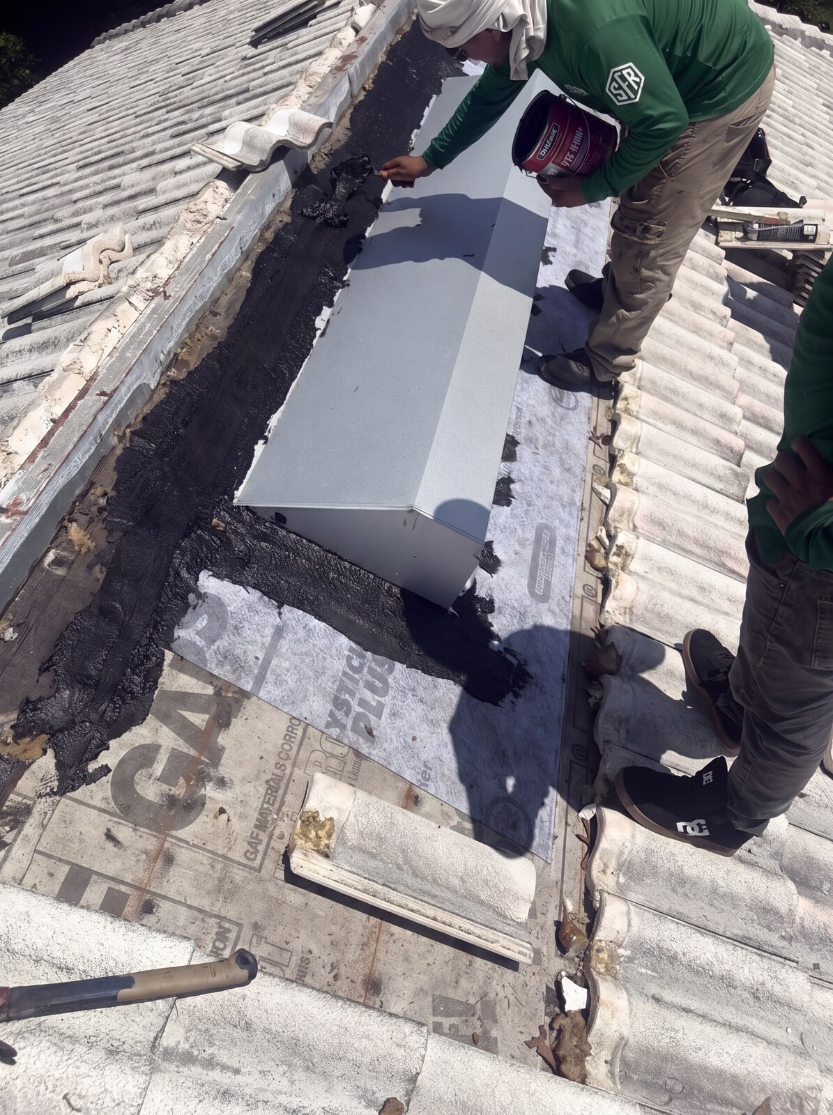 Two Scotti Family Roofing crew members working the ridge cap on a Weeki Wachee FL tile roof